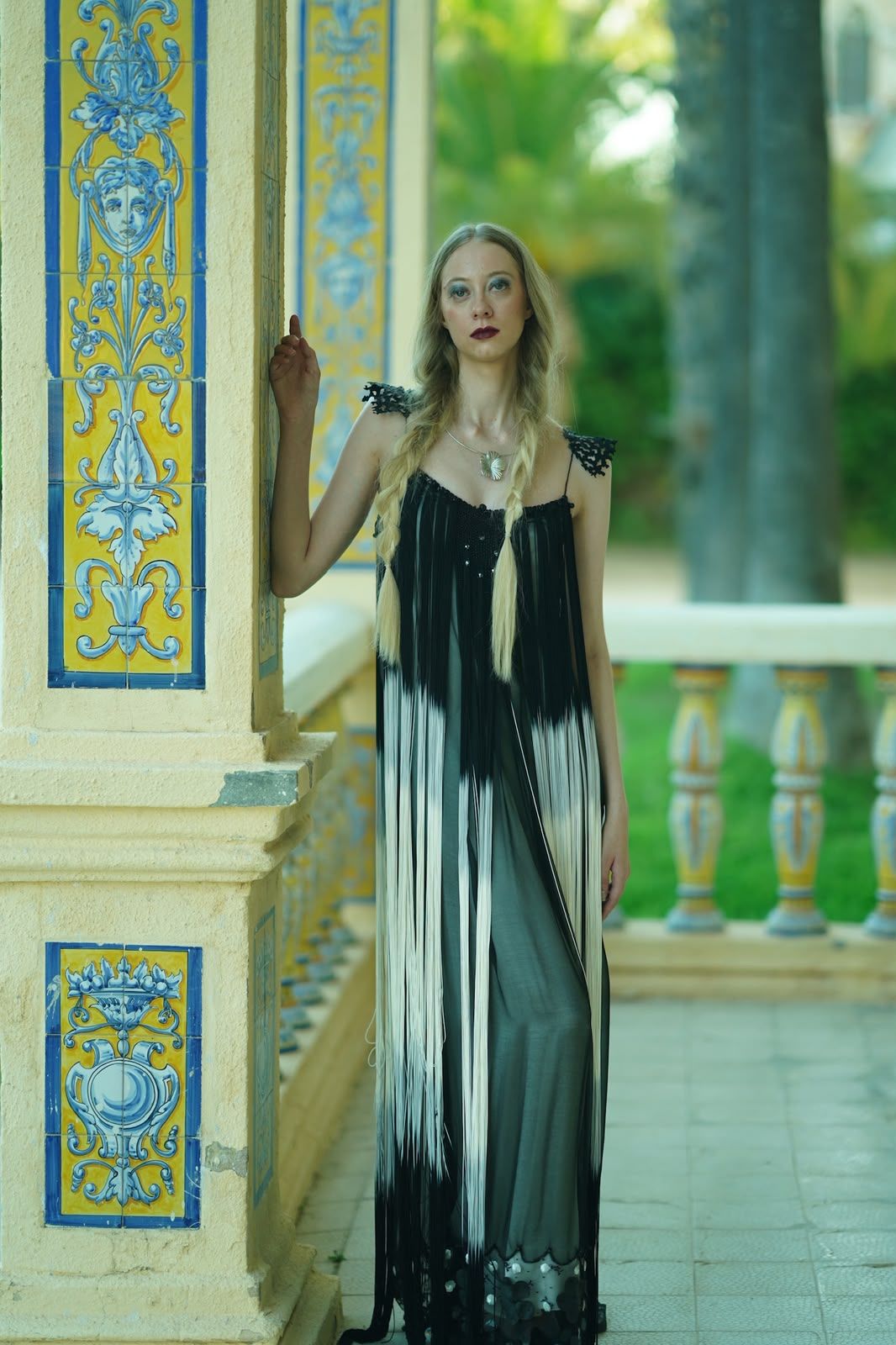 Vestido Fleco apoyado en la columna de azulejo